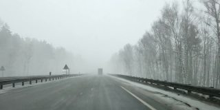 在大雪的冬天，通过高速公路上汽车的挡风玻璃看
