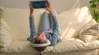 孩子在家里的沙发上玩ipad平板电脑视频素材模板下载