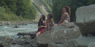 俯视图相当放松的多种族女性泳装享受休闲在山河