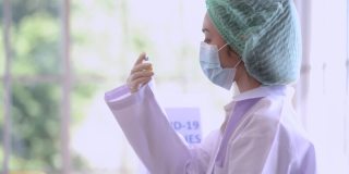 女护士医务人员密切配合准备注射疫苗。女医生戴口罩，保护污染，防止病毒。医疗保健行业的工人生活。