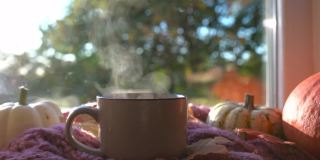 秋天的静物，一杯热茶，南瓜，落叶，窗台上的围巾