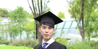 一幅亚洲学生的肖像，戴着学士帽，穿着学位服庆祝毕业