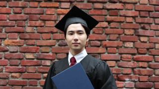 一幅亚洲学生的肖像，戴着学士帽，穿着学位服庆祝毕业视频素材模板下载