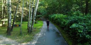 一名男子运动员在公园户外跑步，在森林周围，橡树绿草，年轻持久的运动员跑步健身步道健康运动，户外。成人闲春，跑步者舒展