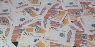 一堆钞票落在装满哥伦比亚钞票的平面上