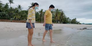 快乐的亚洲孩子们一起在沙滩上踢水嬉水，生活理念。