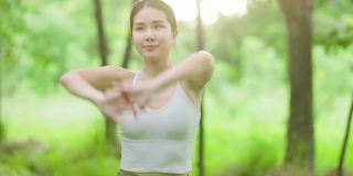 年轻的亚洲女人在花园里练习瑜伽。女性的幸福。模糊的背景。健康的生活方式和放松的观念。年轻的亚洲女孩在公园里做瑜伽。