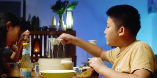 亚洲孩子晚上在家和家人一起吃涮锅涮锅或寿喜烧，这是一种生活理念。