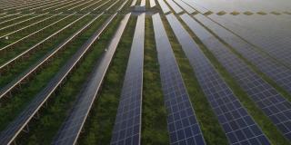 早春日落时，无人机在太阳能农场的大型太阳能电池板上观察。太阳能电池发电厂。录像视频4 k。