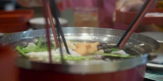 亚洲孩子和家人一起在餐厅吃日式涮锅(Sukiyaki)或日本火锅，生活理念。