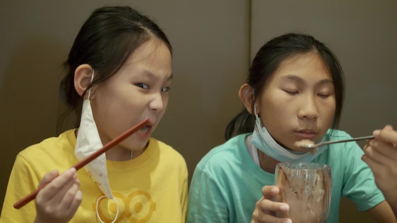 四个亚洲孩子一起在餐厅吃冰淇淋蛋糕庆祝生日，生活理念。
