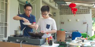 亚洲华人父亲和儿子一起在潮湿的厨房后院周末准备晚餐