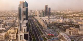 阿联酋迪拜高速公路枢纽的鸟瞰图，日落时交通时间流逝。迪拜市中心著名的谢赫·扎耶德路。从屋顶观看交通和驾驶概念。