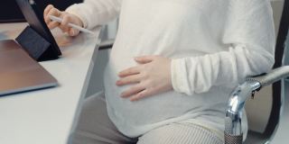 怀孕期间在家通过电子平板电脑远程工作。