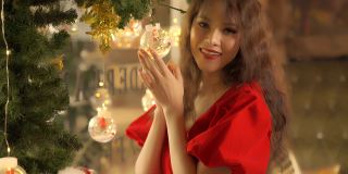 年轻的亚洲女性在圣诞夜装饰仙女灯