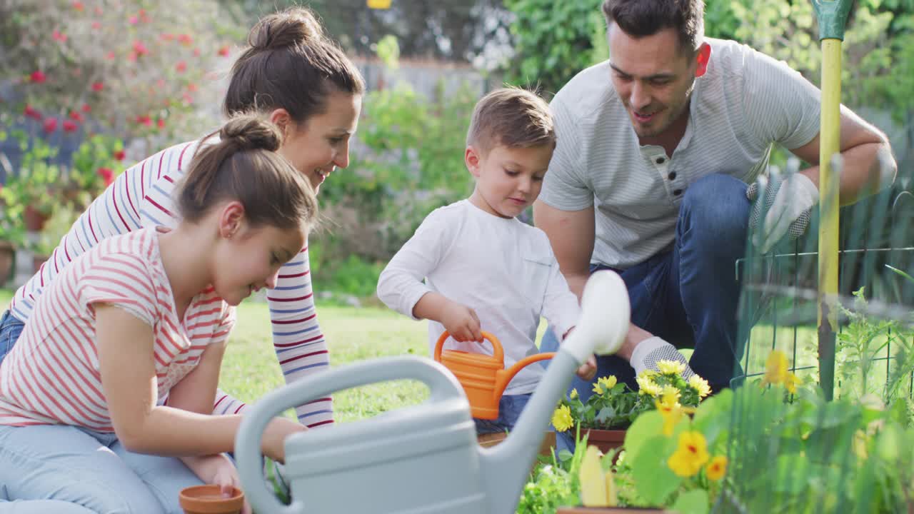幸福的白种人家庭一起园艺和浇灌植物