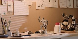 空房间和男孩的工作场所。桌子上有画笔和机器人模型
