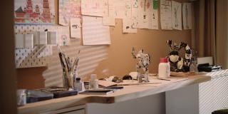 空房间和男孩的工作场所。桌子上有画笔和机器人模型