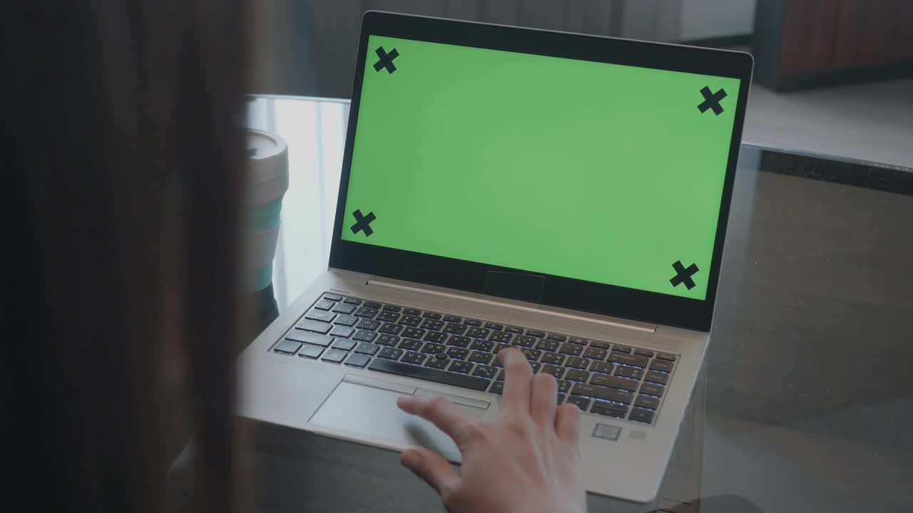 特写女人使用Chroma键屏幕笔记本电脑在家里的桌子上