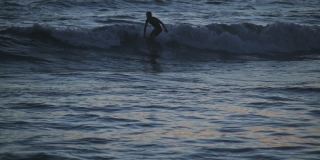 日本濑户岛，日落时冲浪者在海里的视频素材