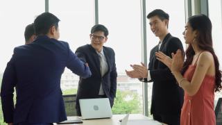 亚洲商务人士会议小组会议在办公室举行。营销团队。老板与客户握手，同事鼓掌或拍手庆祝成功，协议成交视频素材模板下载