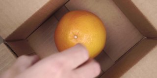 顾客从快递箱里拿了一个成熟的柚子