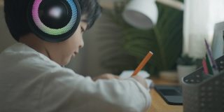 一个戴着耳机在家学习的男孩