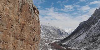 这是初春大雪纷飞的山峡岩石旁的跨度的鸟瞰图。