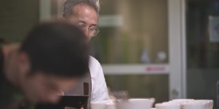 3位专业的亚洲华人高级男子咖啡师、鉴定人、品酒师表演杯咖啡，与同事品尝杯咖啡后在剪贴板上写下