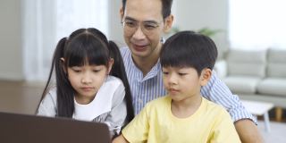 亚洲父亲和孩子使用笔记本电脑。
