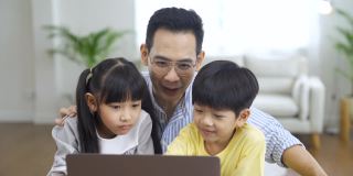 亚洲父亲和孩子使用笔记本电脑。