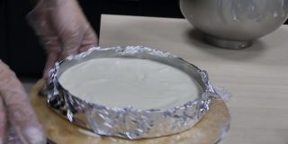 糕点师把面团摇成圆形，然后把它放在桌子上