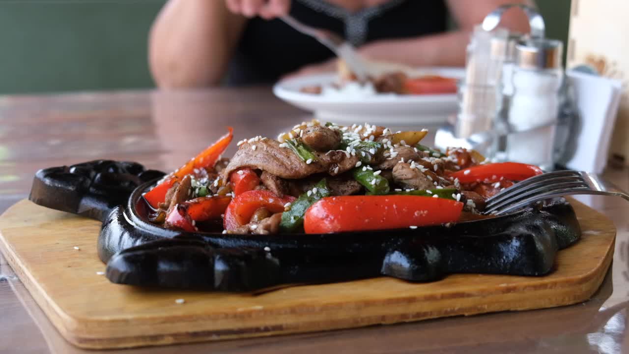 糖醋肉和蔬菜。用生铁锅炒肉、蔬菜和芝麻。正宗的食物的概念。