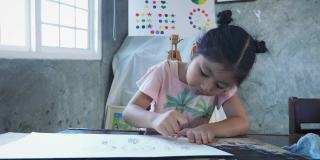 亚洲女孩在家里或小学用纸上用铅笔画画