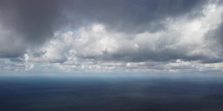 抽象的空气天空和移动的丰满的云在海洋。清澈见底的水面上的小浪从日出起。假日、度假和休闲的概念