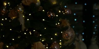 以圣诞蜡烛和装饰为背景的圣诞树上有彩灯。