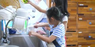 孩子们在学校的厨房里洗碗，孩子们在家里一起帮助做家务