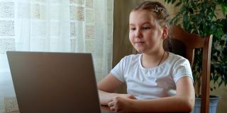 一个小女孩在家里用笔记本电脑学习，老师是语言治疗师。