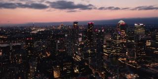 黄昏时分，俯瞰金融中心金丝雀码头的现代高层建筑。从高处照亮了夜城。英国伦敦