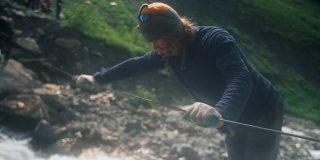 一位游客正在用绳索渡过一条湍急的山河