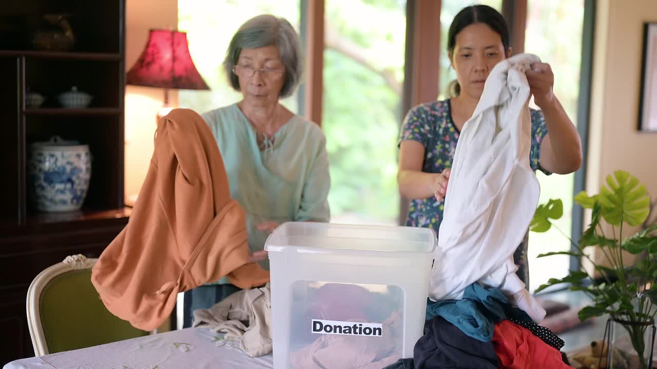 亚洲家庭用捐赠箱准备衣物