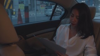 亚洲女商人在时尚的办公室服装工作坐在汽车后座在城市现代城市的早晨。视频素材模板下载