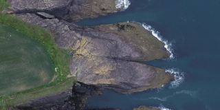 俯瞰岩石的漂亮形状。爱尔兰沃特福德海岸的无人机视频。库珀海岸地质公园