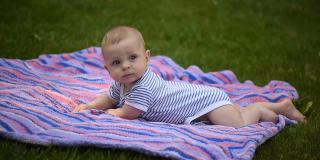 一个可爱的小男孩趴在公园里。