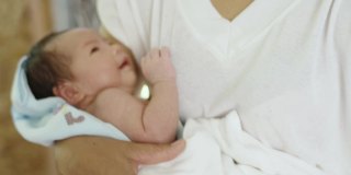 亚洲妇女在怀中安慰女婴。