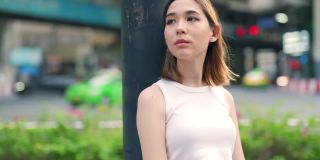 4K年轻亚洲女子肖像走在城市街道