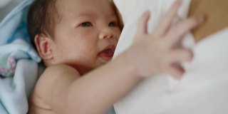 亚洲妇女在怀中安慰女婴。