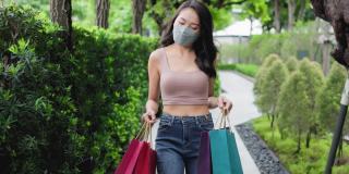 新常态购物，亚洲女性购物在服装商店与面膜。