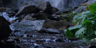 垂直视频。湍急的山河潮湿的岩石，溅起的水花和泡沫。瀑布在背景..