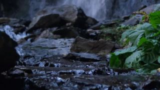 垂直视频。湍急的山河潮湿的岩石，溅起的水花和泡沫。瀑布在背景..视频素材模板下载